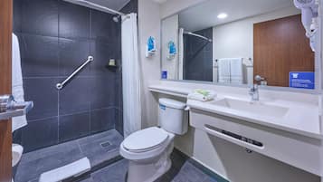 Un baño moderno con ducha, inodoro y lavamanos.