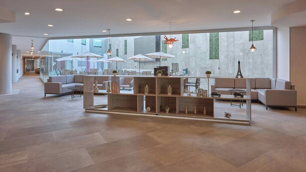 A spacious lobby with modern furniture, large windows, and a central seating area. - City Express by Marriott Ciudad de México Aeropuerto (Mexico City)