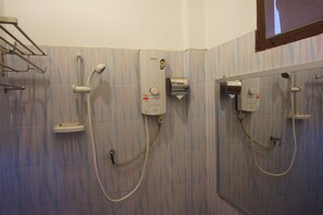 Un bagno con due soffioni doccia, un portasciuga e un water.