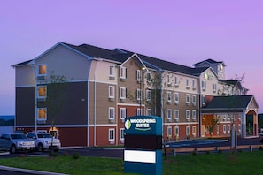 A multi-story hotel with a sign for "Woodspring Suites" and a covered entrance. - WoodSpring Suites Allentown (Allentown)