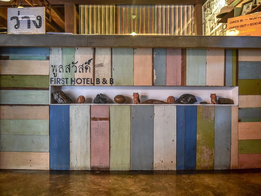 A colorful wooden counter with a sign reading "FIRST HOTEL B&B".