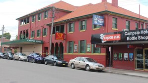 A red building with green shutters, a liquor store, and a hotel. - Campsie Hotel (Campsie)