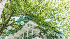 A multi-story building with a central atrium, balconies, and a staircase. - HK Beach Resort (Moalboal)