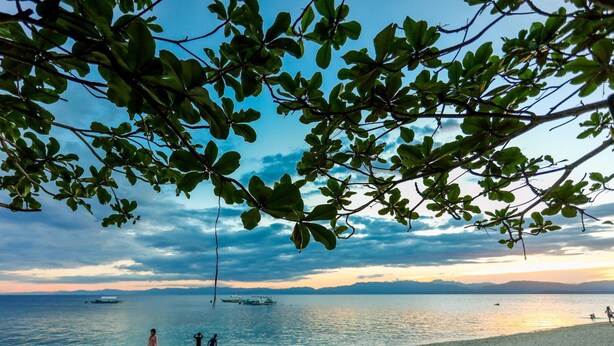 A beach with people, boats, and a clear sky. - HK Beach Resort (Moalboal)