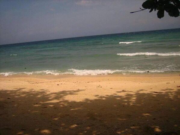 A beach with clear water and a sandy shore.