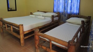 Two wooden beds with white linens, a mirror, a window with blue curtains, and an air conditioning unit on the wall. - Gorion Beach Resort (Samboan)