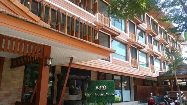 A boutique hotel with a wooden facade, a signboard, and a water feature in front. - MD Boutique Hotel (Chiang Mai)