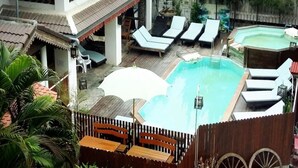A rooftop pool area with lounge chairs, a small pool, and wooden furniture. - MD Boutique Hotel (Chiang Mai)