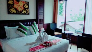 A hotel room with a bed, a window, a chair, and a table. - MD Boutique Hotel (Chiang Mai)