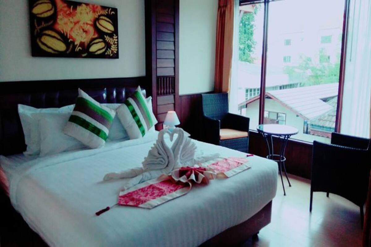 Une chambre d’hôtel avec un lit, une fenêtre, une chaise et une table.