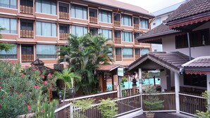 A hotel with multiple balconies, a pool area, and a garden with various plants. - MD Boutique Hotel (Chiang Mai)