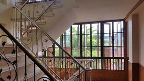 A staircase with ornate metal railings leading to a balcony with large windows. - MD Boutique Hotel (Chiang Mai)