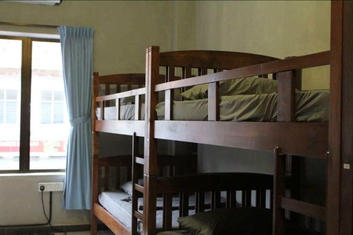 A bunk bed room with a window and curtains.
