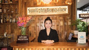 A reception desk at Sunlight Bungalow with a wooden interior, a clock, and a sign indicating room numbers. - Sunlight Bungalow (Phu Quoc)