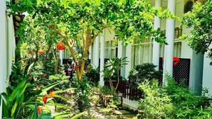 A courtyard with a pathway, surrounded by lush greenery and traditional architecture. - Sunlight Bungalow (Phu Quoc)