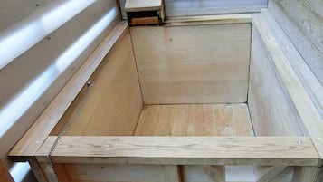 Estructura de cama de madera con cadenas metálicas y cabecera de madera.