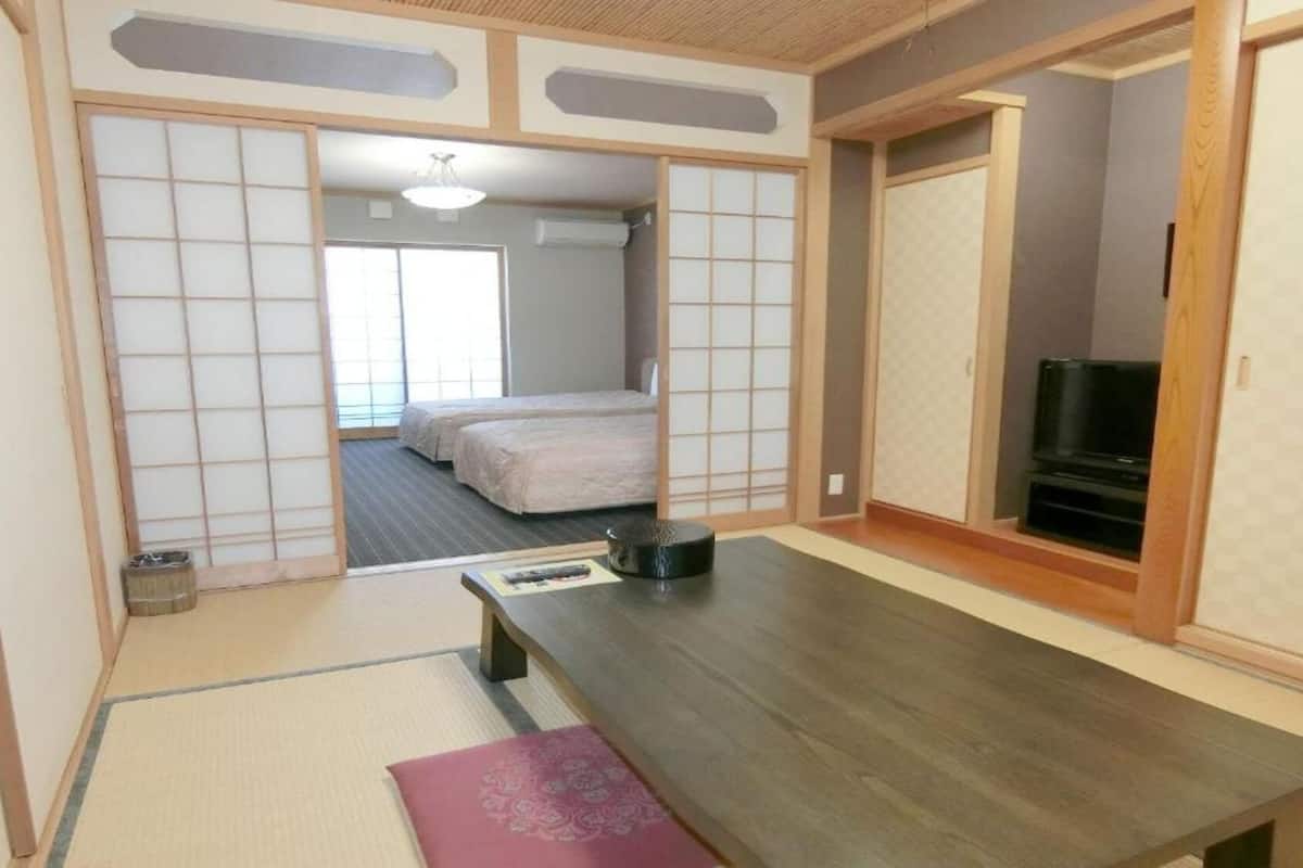 A traditional Japanese-style room with tatami flooring, a low table, and sliding doors.
