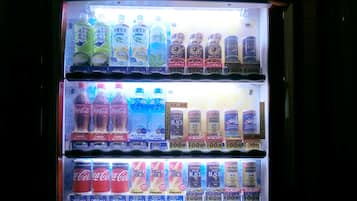 Un distributeur automatique proposant une variété de boissons, notamment du Coca-Cola et d’autres boissons.