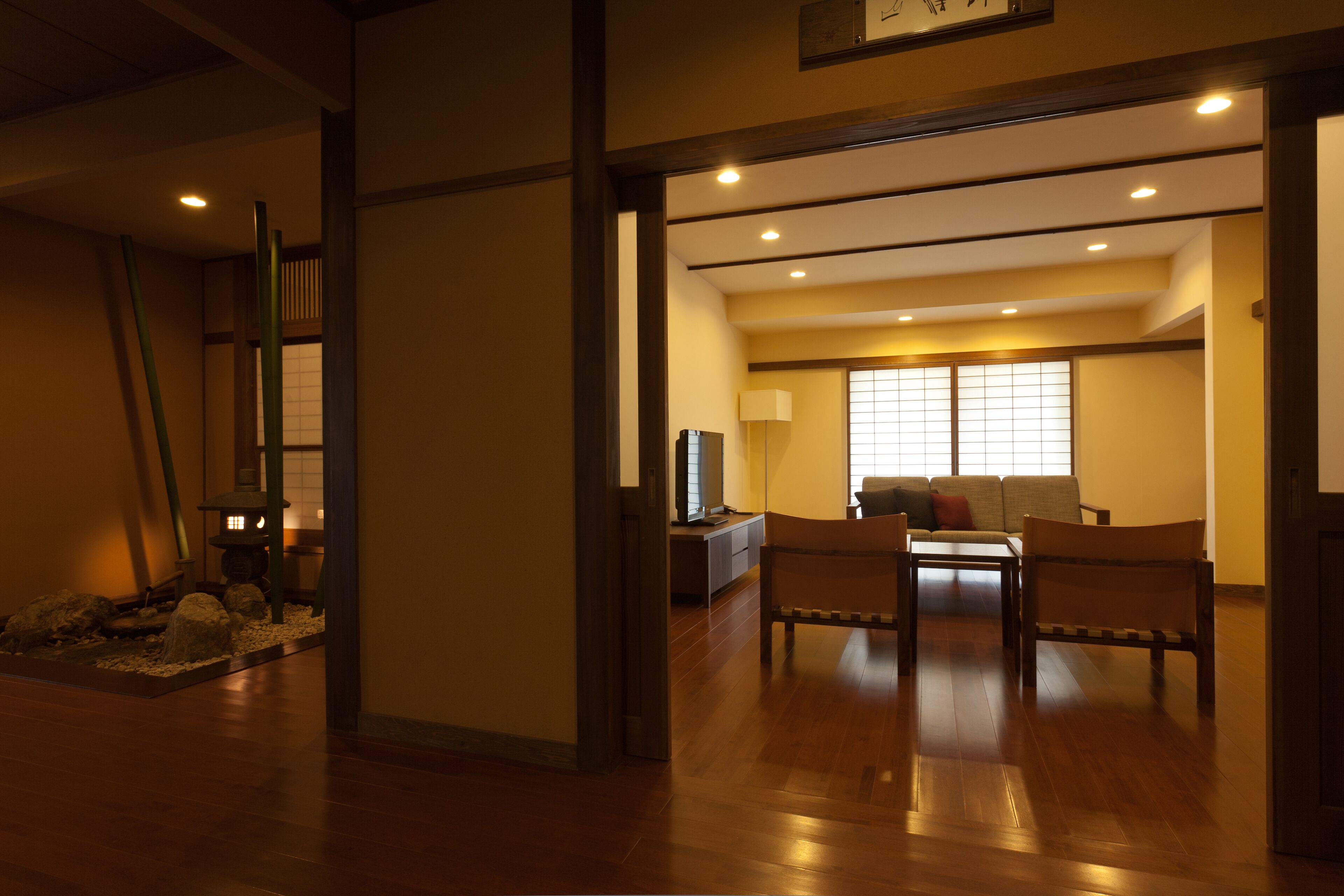 Ein traditioneller japanischer Raum mit Tatami-Böden, einem niedrigen Tisch und einer Couch.