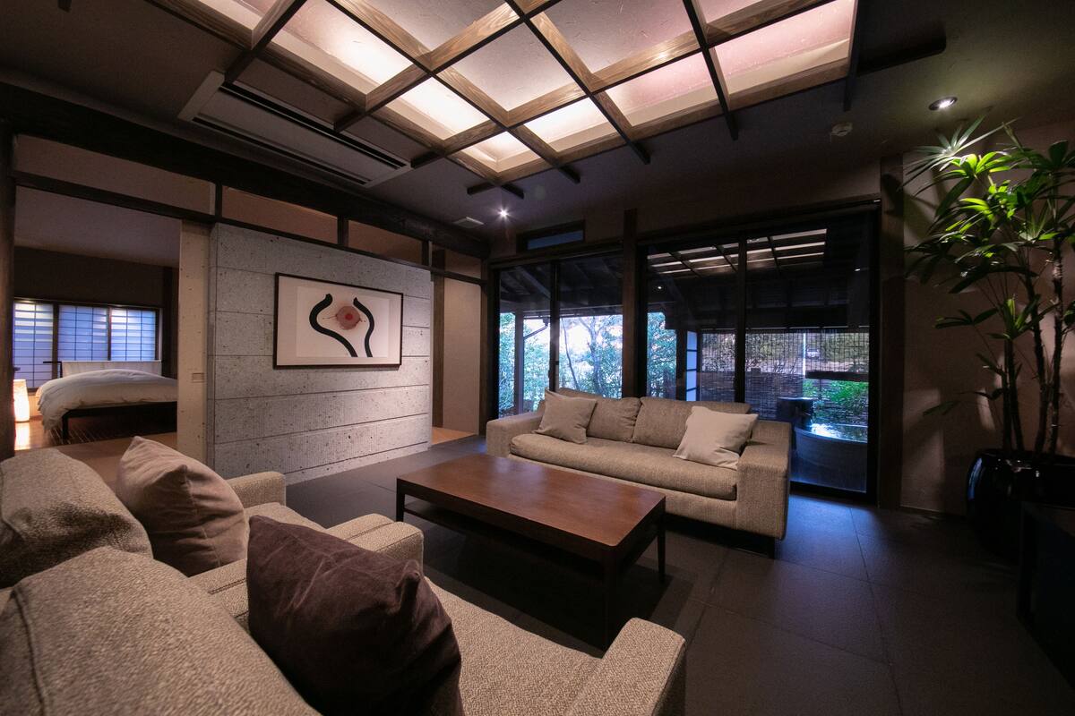 A modern living room with a sofa, coffee table, and a painting on the wall.
