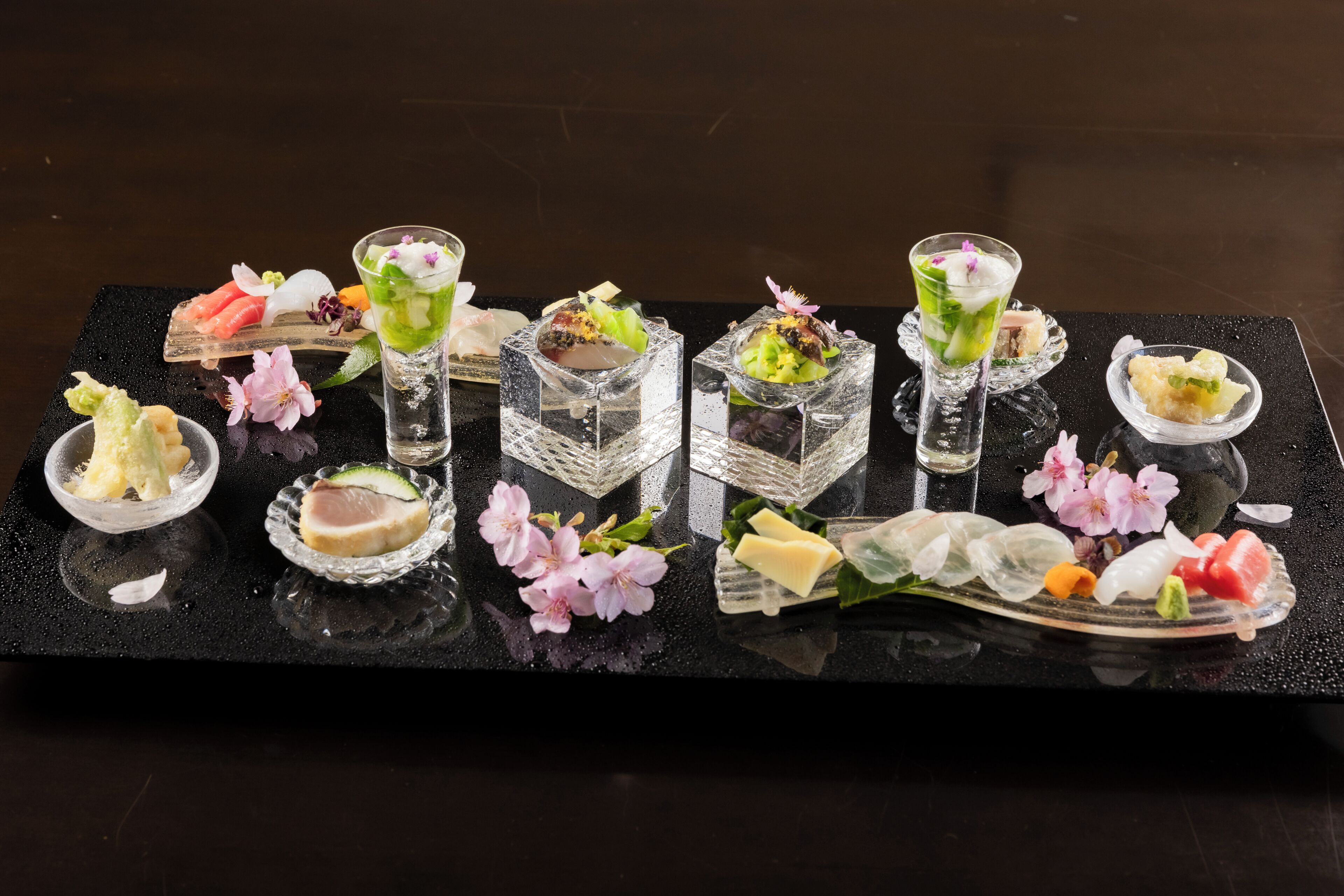 A tray of food and drinks with various dishes and garnishes.