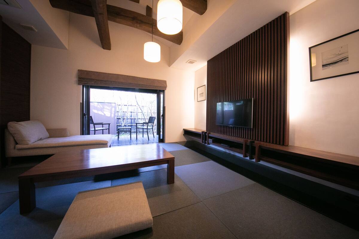 A modern living room with a sofa, a coffee table, and a television.