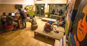 Un espace commun aménagé avec des sièges, une table et une grande fenêtre.