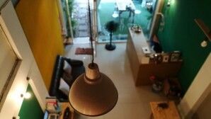 Ein Blick von oben auf einen Raum mit einer Hängelampe, einem Holztisch und einer grünen Wand.