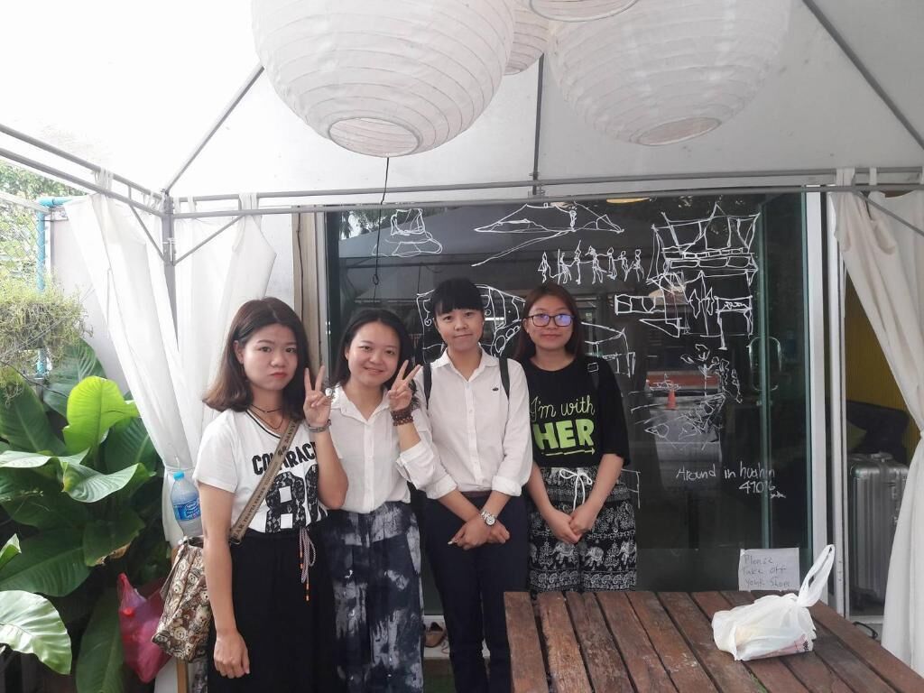 Four people standing in front of a glass wall with drawings and text.