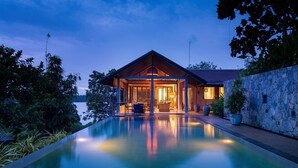 A modern house with a swimming pool, surrounded by lush greenery and a stone wall. - Sea Heart House on Koggala Lake (Koggala)