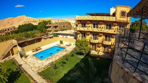 Un hotel con piscina, mobiliario exterior y vistas del paisaje circundante.