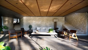 A spacious living area with a stone wall, a sofa, and multiple chairs.