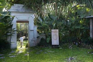 A pathway leading to a building with a sign reading "Planta". - Planta Luxury Boutique Resort (Canggu)