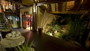 A wooden deck with potted plants and a small rock garden.