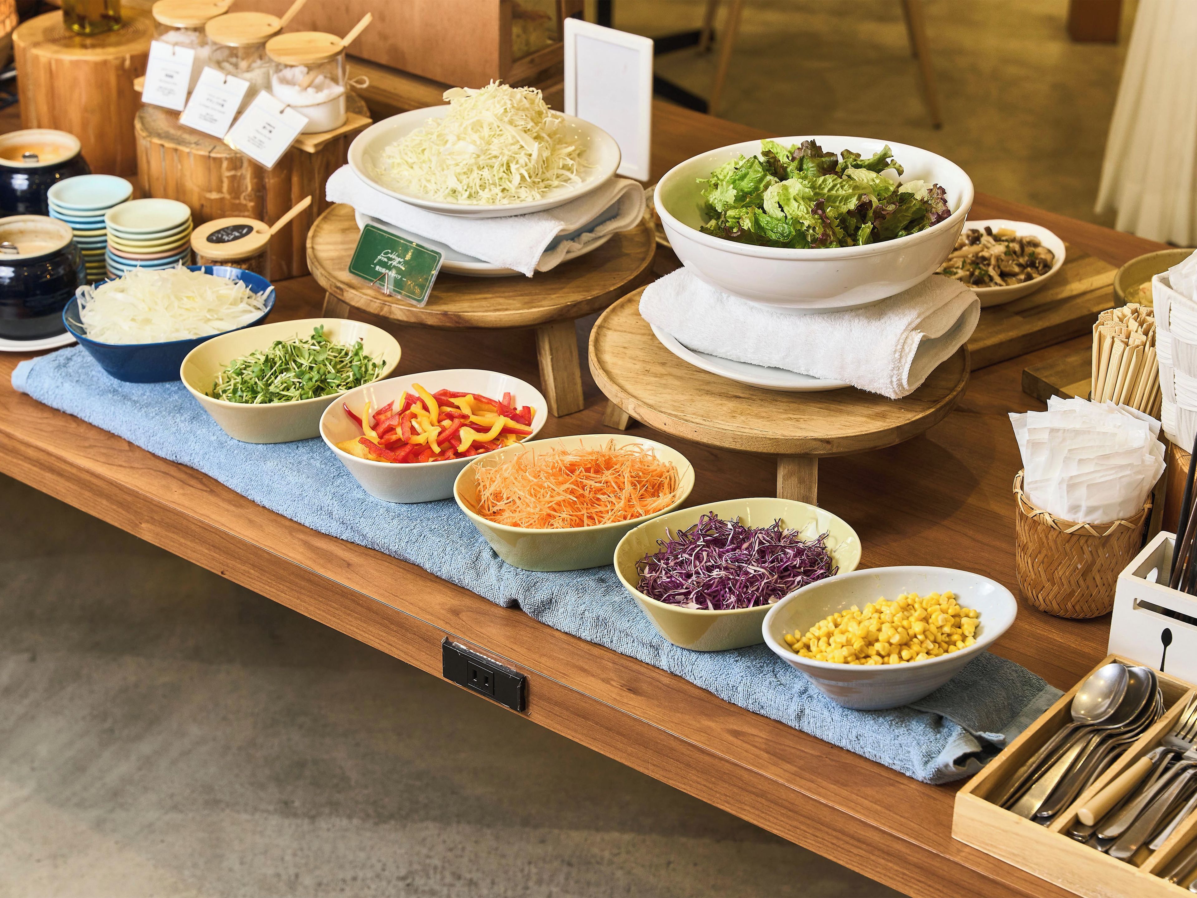 A buffet table with various food items and condiments.