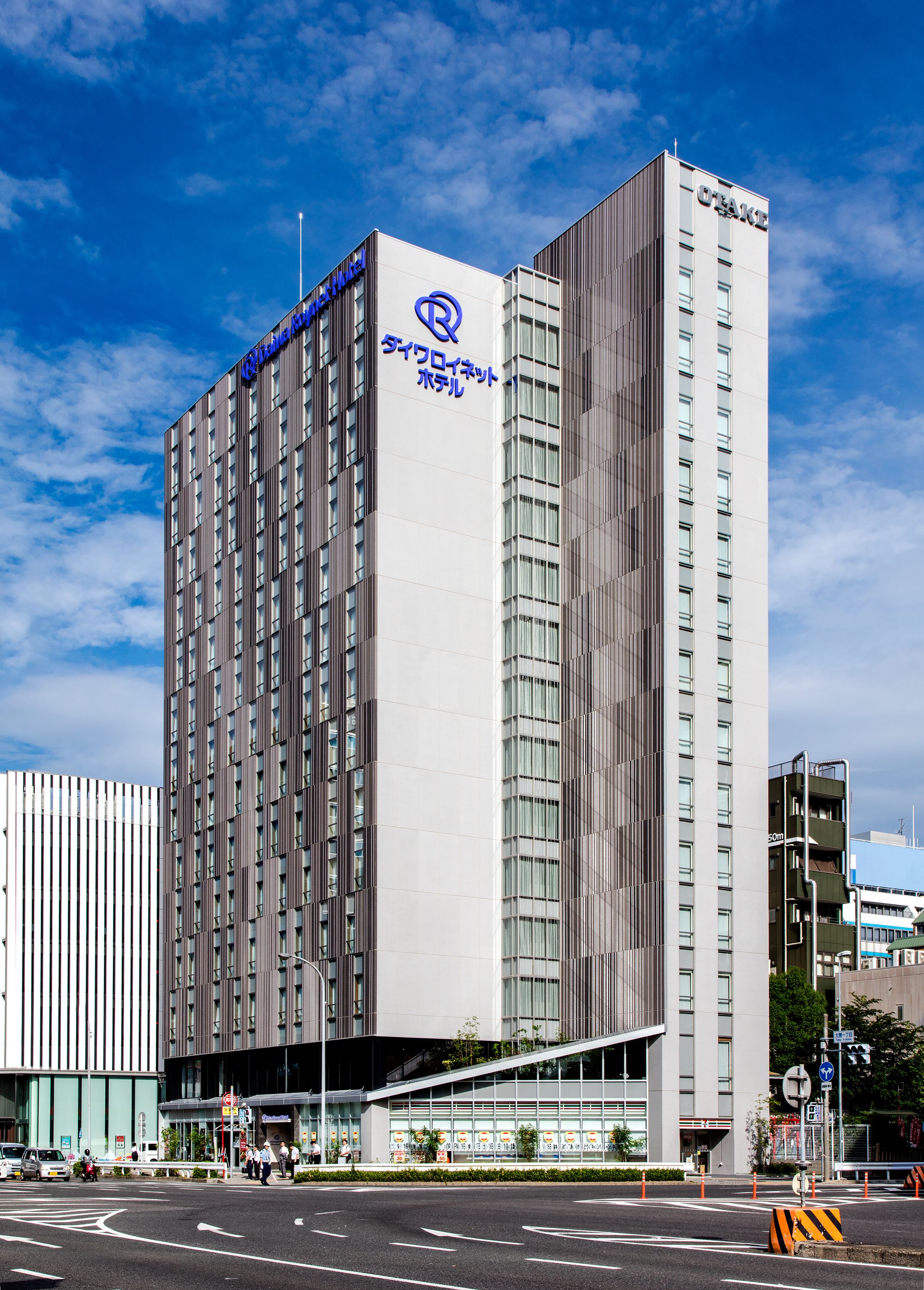 Un moderno edificio de hotel con un logotipo y señalización destacados.
