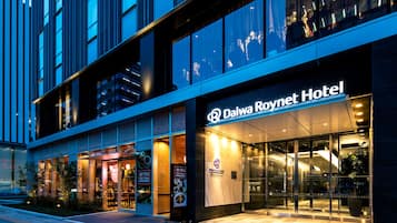 Exterior del Hotel Daiwa Roynet, con fachada moderna, amplia entrada de vidrio y señalización visible.