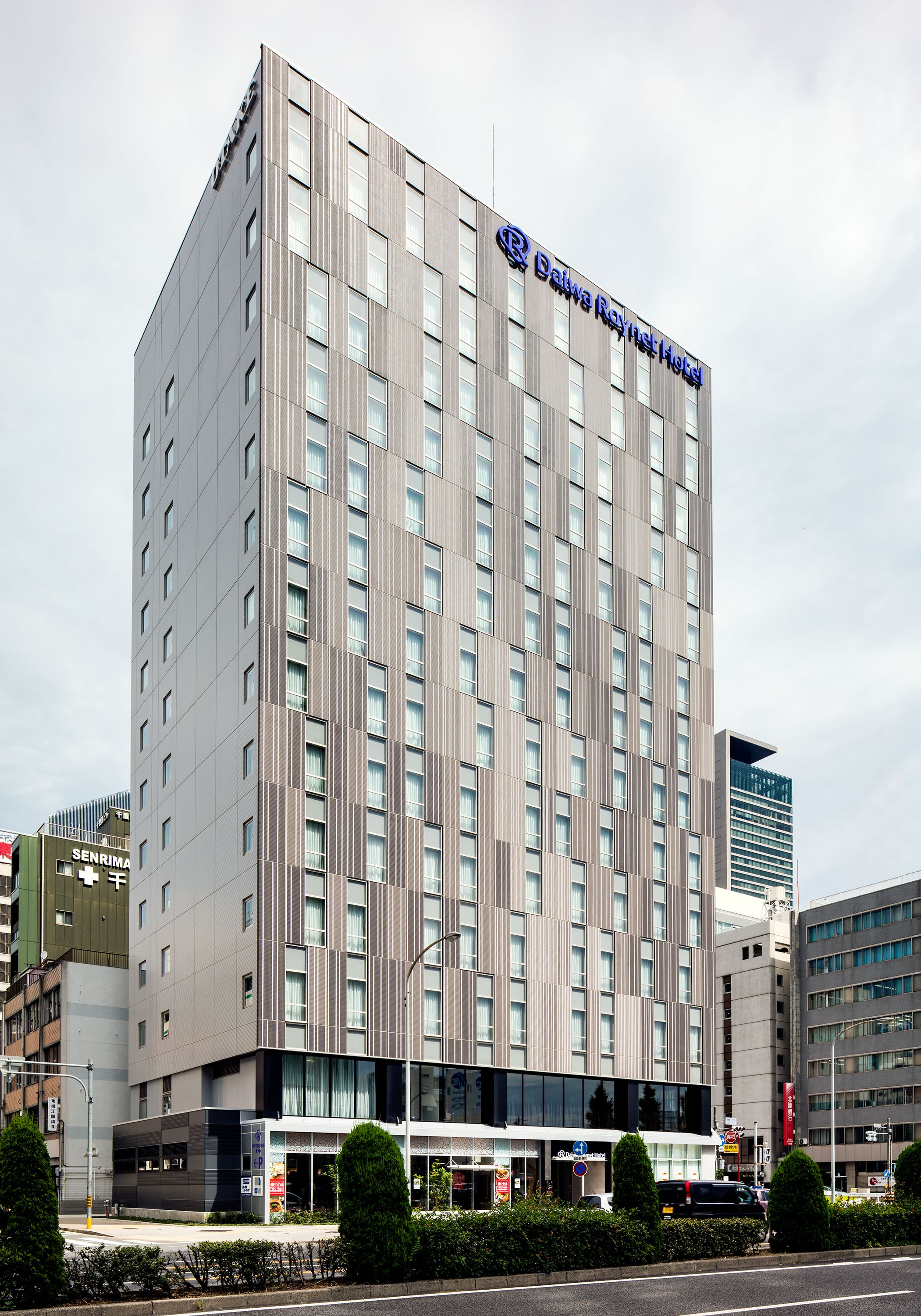 Un moderno edificio de hotel con un letrero llamativo del Hotel Daiva Reynet.