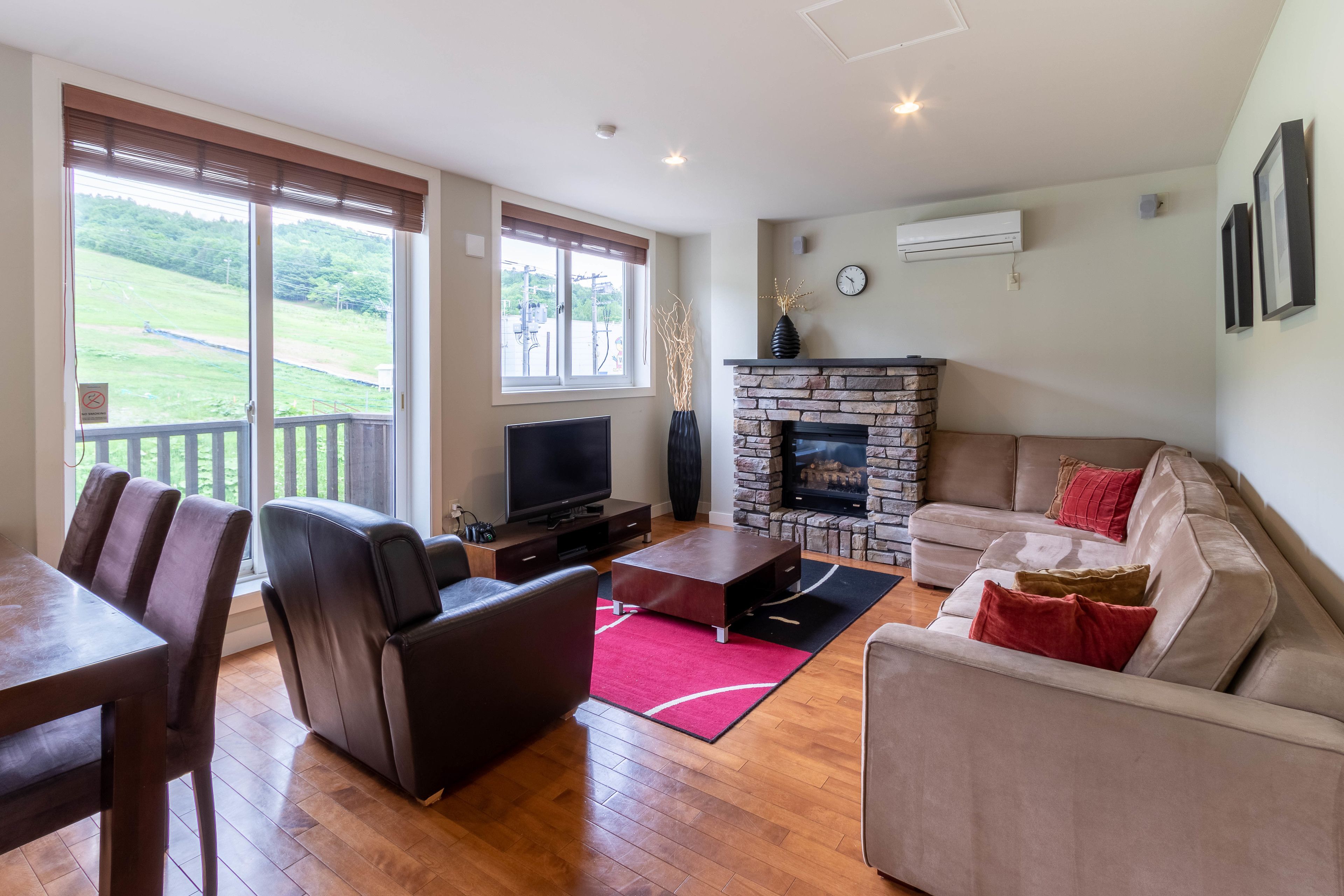 A living room with a fireplace, a television, and a dining area with a table and chairs.
