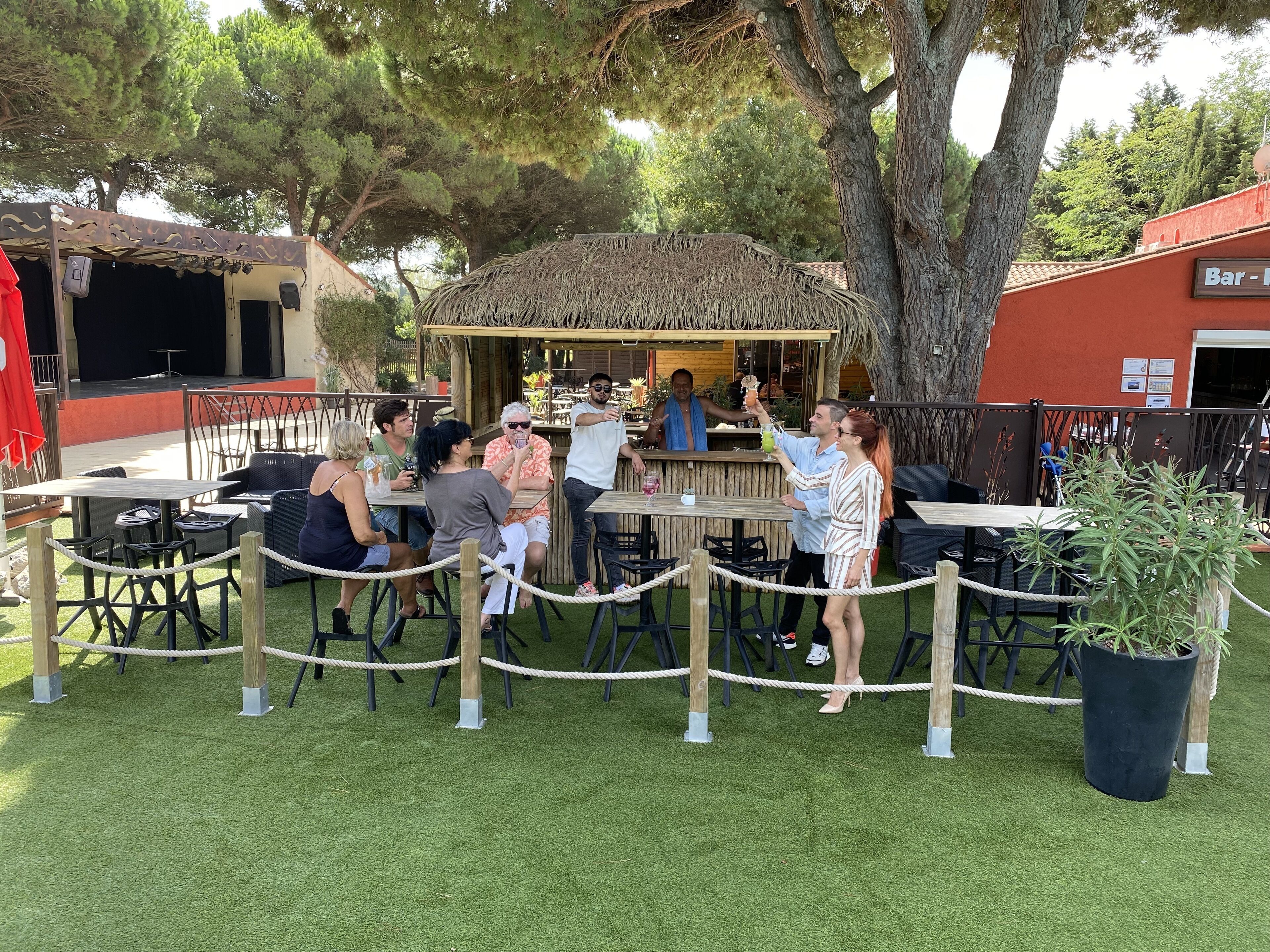 An outdoor seating area with tables and chairs, surrounded by a rope barrier.