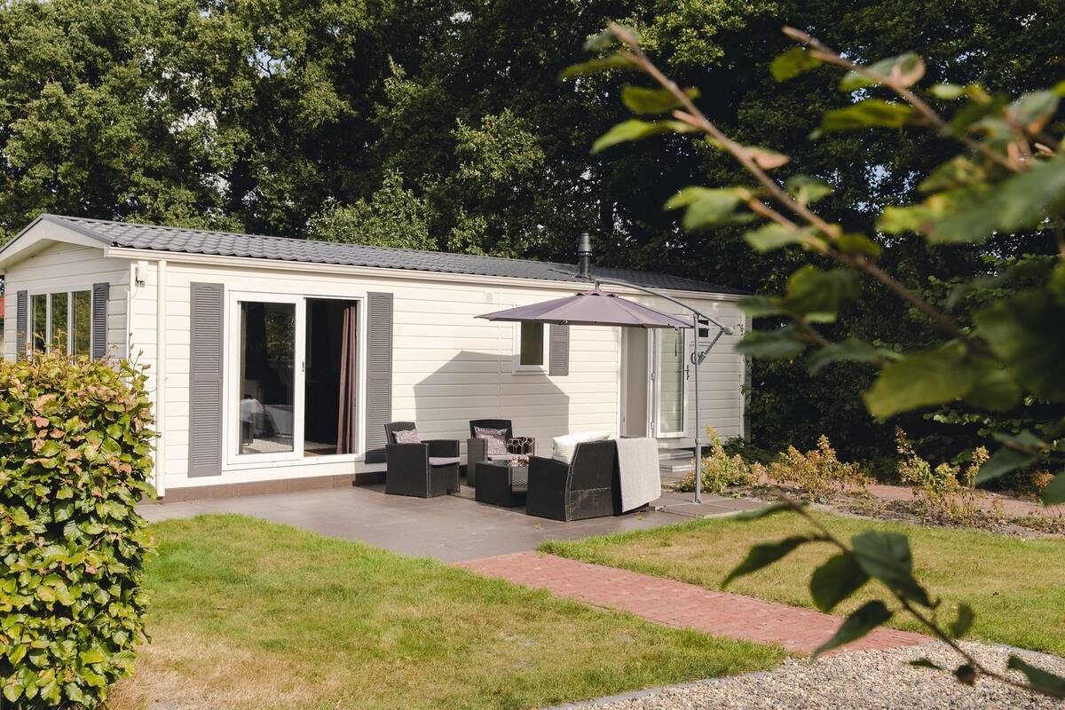 A mobile home with a patio area featuring outdoor furniture and a covered seating area.