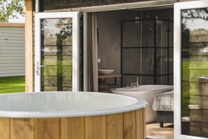 An outdoor hot tub and a walk-in shower with a large window. - Buitenplaats Holten (Rijssen)