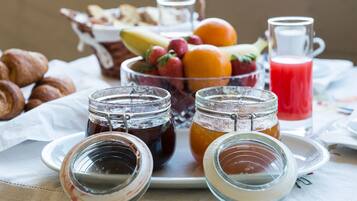 Ein Frühstücksbuffet mit Gebäck, Früchten und Getränken.