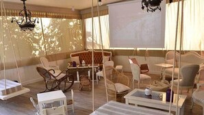 A spacious room with a large bed, a swing chair, and a seating area with a table and chairs. - Hotel Ristorante Milano (Borgo a Mozzano)