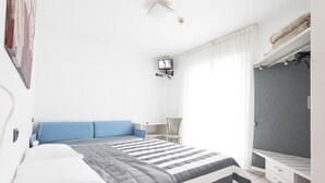 Un dormitorio moderno con cama, escritorio y zona de estar.