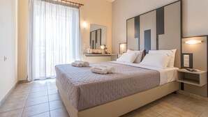 A modern hotel room with a large bed, a bedside table, a nightstand, a mirror, and a window with curtains.