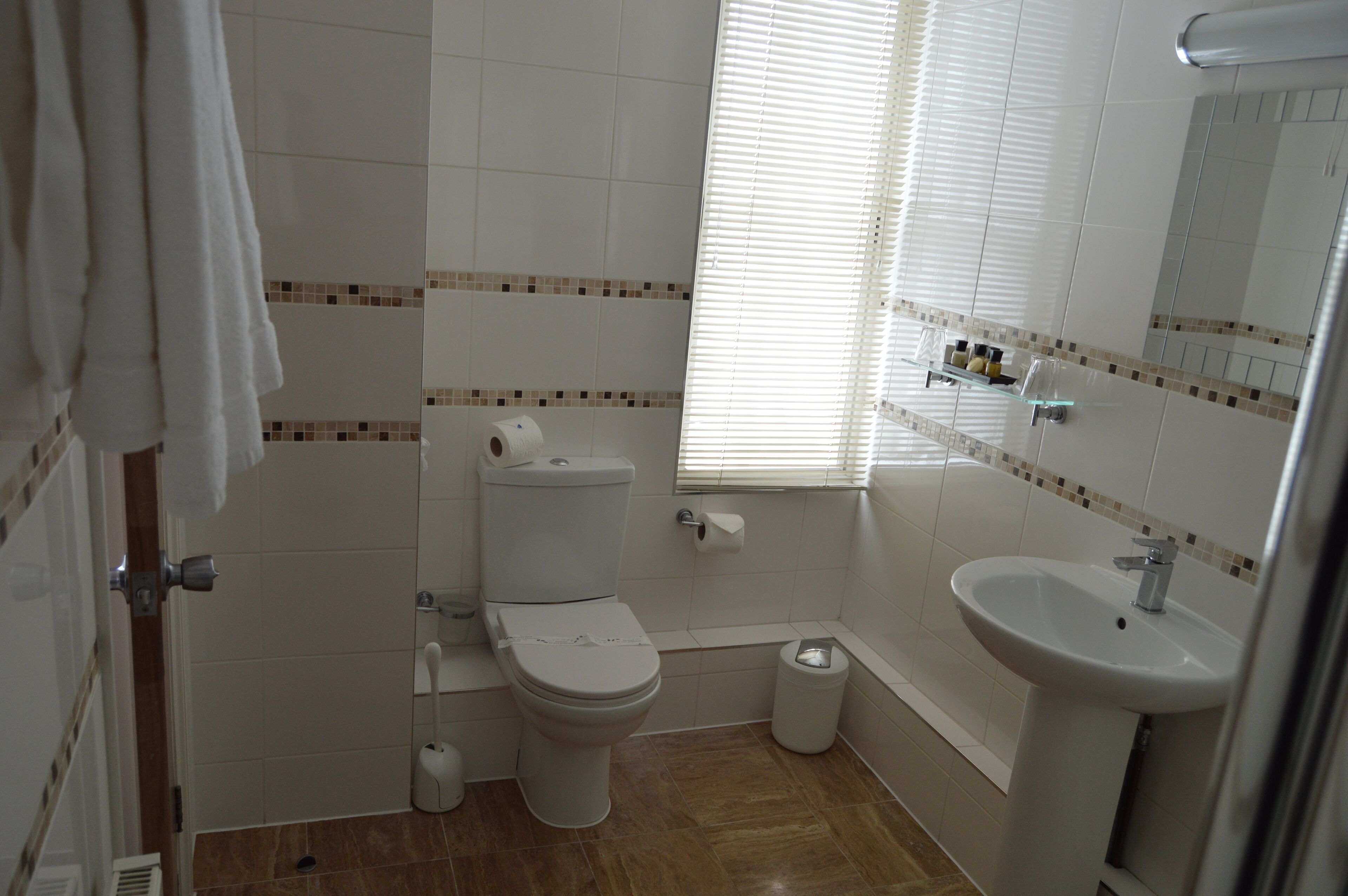 Un baño con inodoro, lavamanos y ventana.