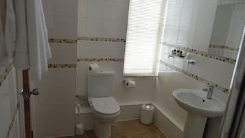 Un baño con inodoro, lavamanos y ventana.