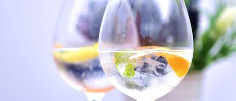 Deux verres contenant une boisson claire, avec des tranches de fruits, sur une table en bois.