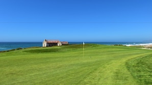 A golf course with a clubhouse and ocean view. - Mercearia d'Alegria Boutique B&B (Peniche)